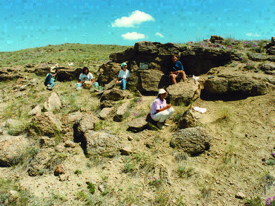 a group of people sitting on an outcropping of rock.