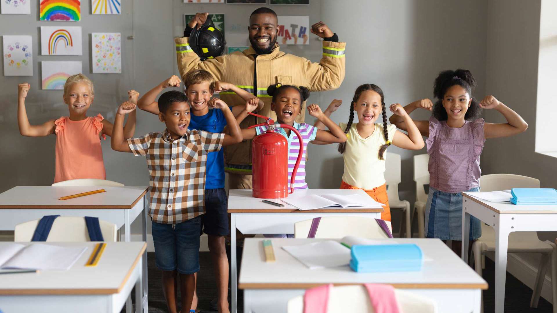 Students and a fire fighter in the classroom, showing "strong arms"