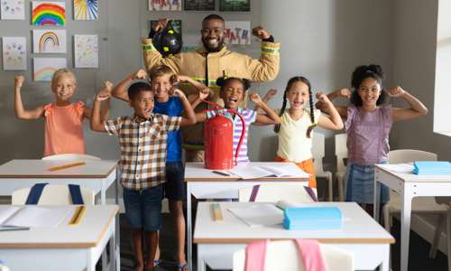 Children and a firefight smile for the camera and show "strong arms"