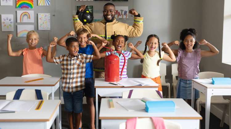 Students and a fire fighter in the classroom, showing "strong arms"