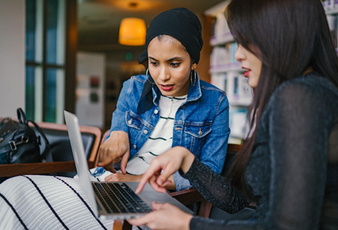 Two educators work together using a computer.