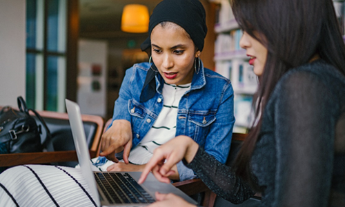 Two educators work together using a computer.