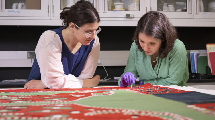 Two conservators looking at a textile.