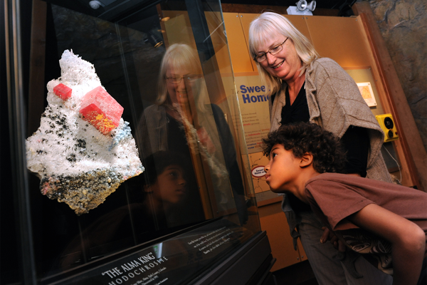 Two people admiring the Alma King, the finest mineral specimen of Rhodochrosite in the world. 