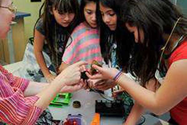 four students examine an object 