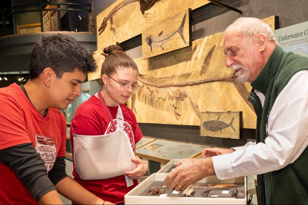 Volunteer shows off collections items in Prehistoric Journey