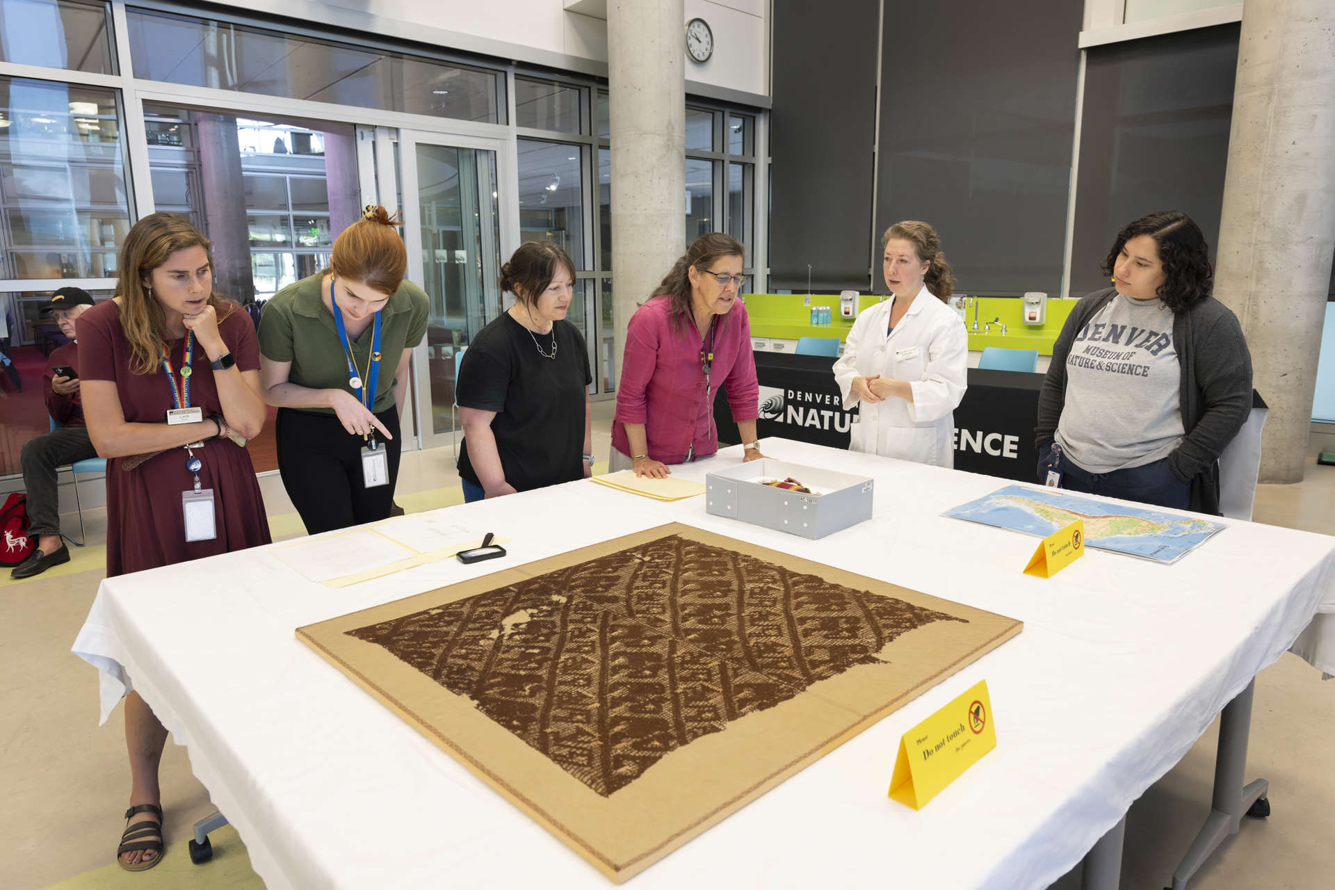 Museum Visitors and DMNS staff discuss textiles during the Archeological Textiles Conservation in Action