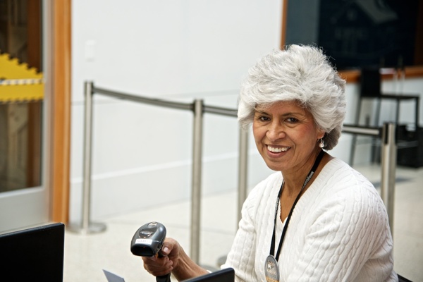 Woman scans people's tickets at an exhibit entry 