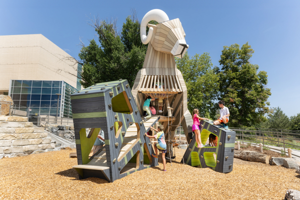 Children play on a large bighorn ram sculpture 