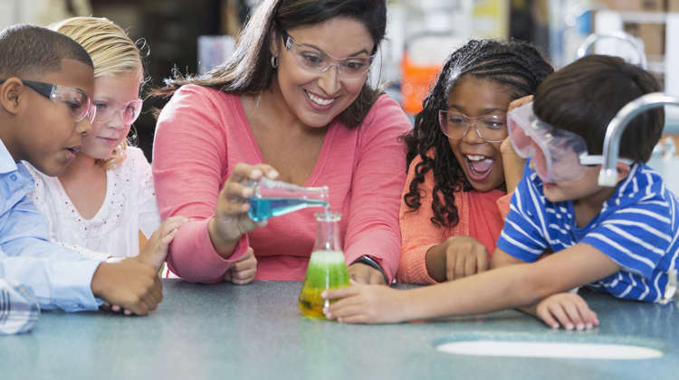 Students and their teacher conduct a chemistry experiment.