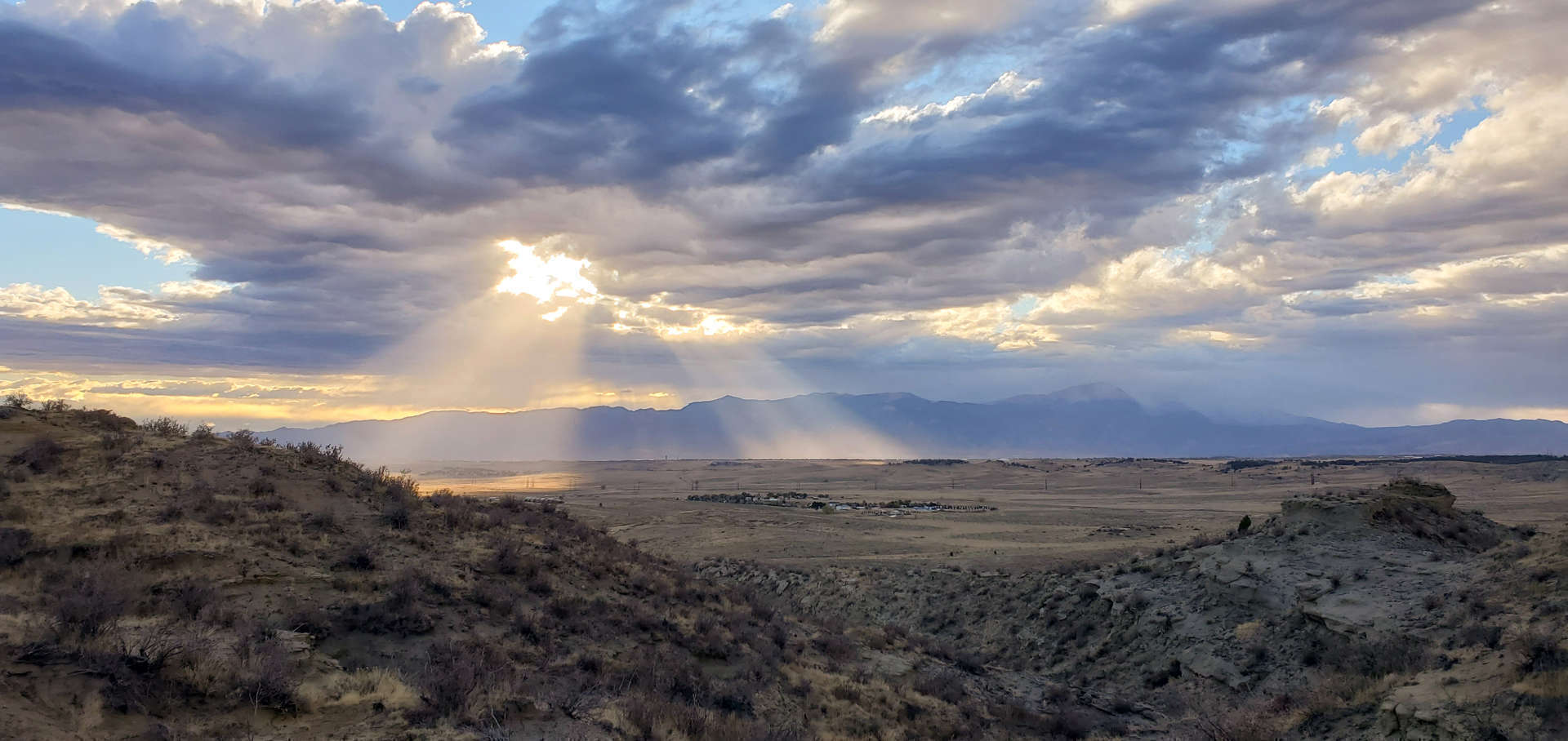 Panaromic view of a partly cloudy sky with sun beaming through, from Corral Bluffs looking west.