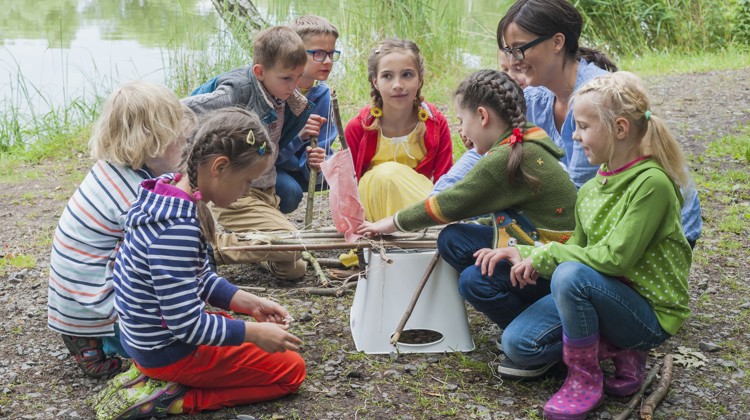 Teacher and students doing an experiment next to a lake